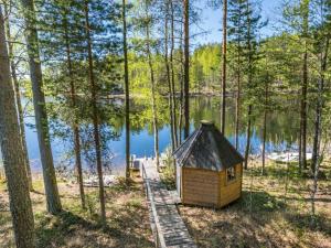 a cabin in the woods next to a lake at Holiday Home Patu by Interhome in Pihlajaniemi