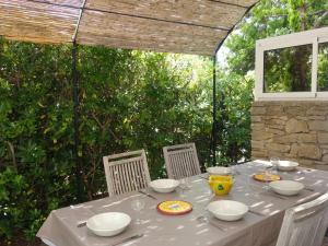 a table with a white tablecloth and bowls and plates at Holiday Home Le Mazet by Interhome in Les Lecques