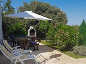 a patio with a table and chairs and an umbrella at Holiday Home Martina by Interhome in Valdebek