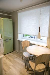 een keuken met een tafel en een groene koelkast bij Vintage style apartment 1 km from the beach in Pärnu