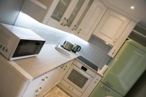 een kleine keuken met een magnetron en een wastafel bij Vintage style apartment 1 km from the beach in Pärnu