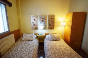 a room with two beds and a desk and a window at Christys Palace Hotel in Pedoulas