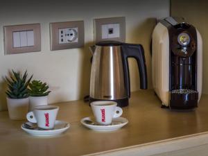 two coffee cups sitting on a counter with a coffee maker at Hotel Villa Casanova in Lucca