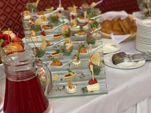 una mesa con platos de aperitivos y una jarra de zumo en Greenwood Hotel, en Moscú