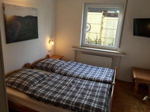 una camera con un letto con una coperta a quadri di Ferienhaus Adele a Bad Neuenahr-Ahrweiler