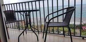 a chair on a balcony with a view of the beach at Kvariati Apartment in Kvariati
