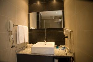 a bathroom with a white sink and a mirror at Surmeli Istanbul Hotel in Istanbul