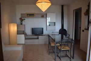 uma sala de estar com uma mesa e uma televisão em Appartamento Supramonte em Montemassi