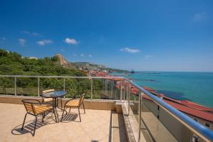 einen Balkon mit Stühlen, einem Tisch und Meerblick in der Unterkunft Balchik Sea View Apartments in Princess Residence in Baltschik