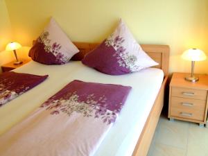 1 dormitorio con 1 cama con almohadas moradas y rosas en Comfort Apartments SNF zertifiziert, en Gronau