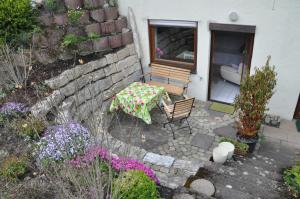 a patio with a table and chairs and flowers at Ferienwohnung Fischer in Frickingen