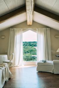 a bedroom with a large window with white curtains at Nontiscordardimé B&B Villa Agriturismo in Civitanova Marche