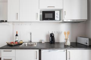 a kitchen with a stove, microwave, sink and dishwasher at Apartments Center Alfama in Lisbon