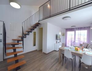 a kitchen and dining room with a staircase in a house at Apartments Medna in Čižići