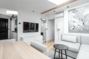 a white living room with a table and a couch at VIU The Roof Apartment in Sopot