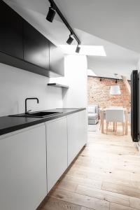 a kitchen with white cabinets and a sink and a table at VIU The Roof Apartment in Sopot