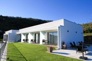 ein weißes Haus mit Rasen davor in der Unterkunft Casa Miradouro in Mesão Frio