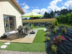 a patio with a table and an umbrella at Le Messimy in Charnoz