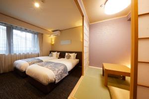 a hotel room with two beds and a window at Rinn Miyagawacho Grande in Kyoto