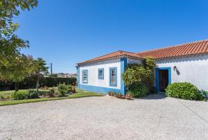 ein weißes und blaues Haus mit Auffahrt in der Unterkunft FLH Ericeira Country House in Ericeira