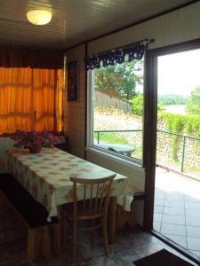 uma sala de jantar com uma mesa e uma grande janela em Pokoje nad jeziorem Mazury em Dabrówno
