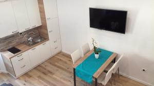 a kitchen with a table and a television on a wall at Apartmaji Apollonio in Izola