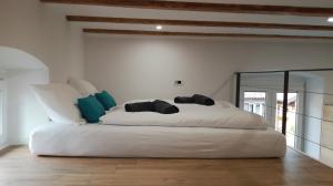 a large white bed in a room with a mirror at Apartmaji Apollonio in Izola