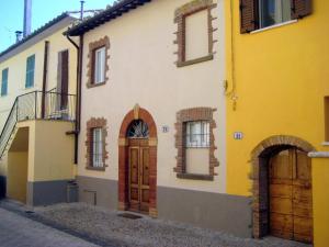 un edificio blanco y amarillo con puerta y ventanas en Casa Mimmo, en Castiglione in Teverina