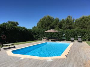 a swimming pool with a table and chairs and an umbrella at L&F House in Algoz