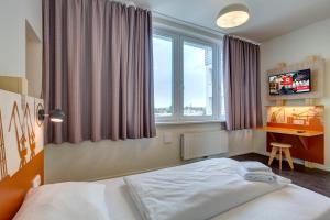 Säng eller sängar i ett rum på MEININGER Hotel Hamburg City Center