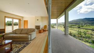 a living room with a couch and a large window at Casa Panorâmica Aurora in Celorico de Basto
