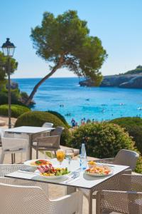 a table with food and a view of the ocean at Inturotel Esmeralda Park in Cala d´Or