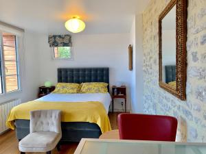 a bedroom with a bed and a red chair at Villa kahlo Omaha Beach in Colleville-sur-Mer
