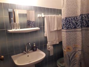 y baño con lavabo, aseo y espejo. en Marialena Pension, en Iräon