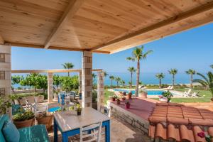 an outdoor patio with tables and chairs and a pool at Aneria Suites in Episkopi