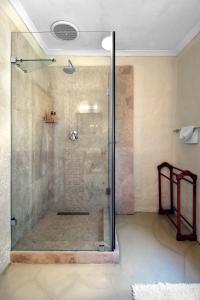 a shower with a glass door in a bathroom at Bo La Motte Farm Cottages in Franschhoek