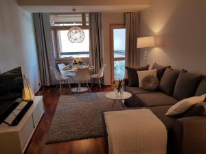 a living room with a couch and a table at 2ndhomes Deluxe Kamppi Center Apartment with Sauna in Helsinki