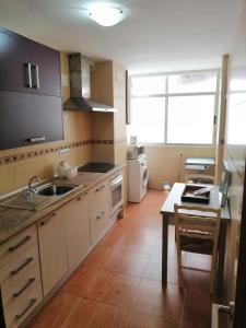 uma cozinha com um lavatório e uma mesa em Villa Carmen em San Juan de Alicante