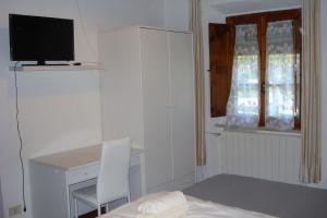 una camera da letto con un letto, una scrivania e una televisione di Podere San Francesco a Volterra
