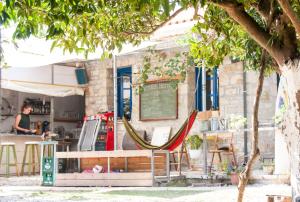 a restaurant with a hammock in front of it at Himara Hostel in Himare