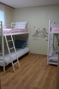 a room with two bunk beds and a wall with a mural at Coco Guest House in Incheon