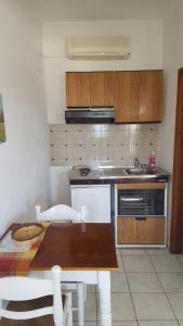 a small kitchen with a table and a sink at Aeolos Hotel Apartments in Gythio