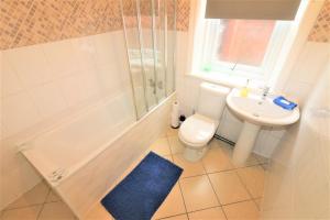 La salle de bains est pourvue de toilettes, d'un lavabo et d'une douche. dans l'établissement Marley Mansion Apartments - Borough, à Birkenhead