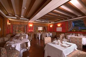 restauracja ze stołami i krzesłami z białym blatem w obiekcie Boutique Hotel Villa Blu Cortina D'Ampezzo w mieście Cortina dʼAmpezzo