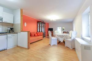 a living room with an orange couch and a table at Landhaus Kaltenborn in Trebsen