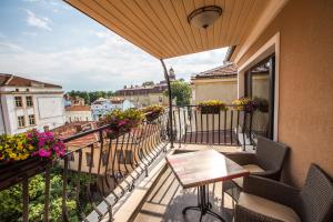 a balcony with a table and chairs and flowers at 8 1/2 Art Guest House in Plovdiv