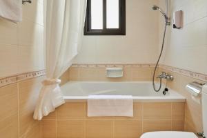 a bathroom with a bath tub and a toilet at Kyklades Angie Resort in Protaras