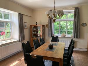 Un comedor con mesa y sillas de madera. en Hof Olde Warft, en Oldenswort