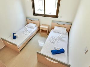 une petite chambre avec deux lits et une fenêtre dans l'établissement Kyklades Angie Resort, à Protaras