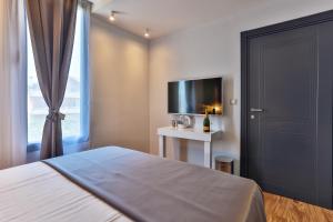 a bedroom with a bed and a tv and a window at Hotel M in Podgorica